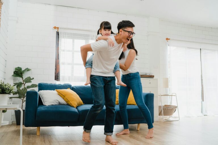 A father giving his daughter a piggyback ride in the living room