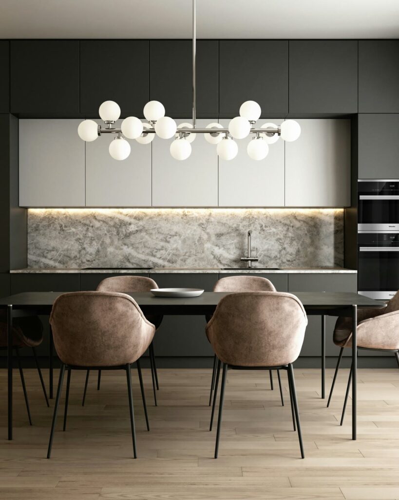 A finished dark kitchen and dining room under a glowing globe chandelier